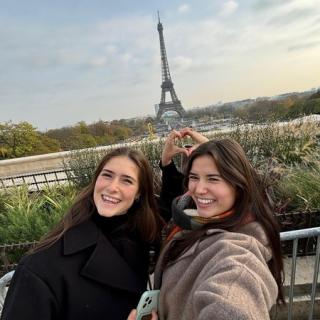Two people posing with the Eiffel Tower in the background