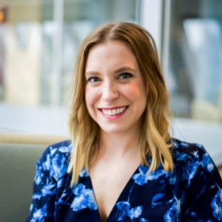 Abby Baric headshot, smiling in sun lit room