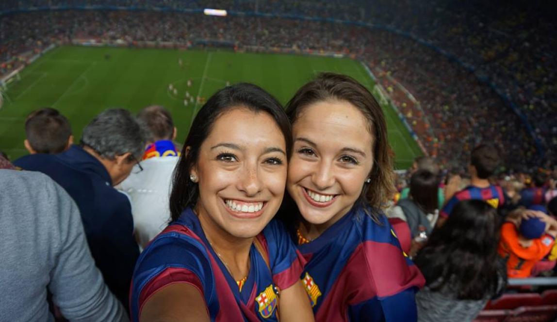 two students pose for a photo at a Barcelona football game.