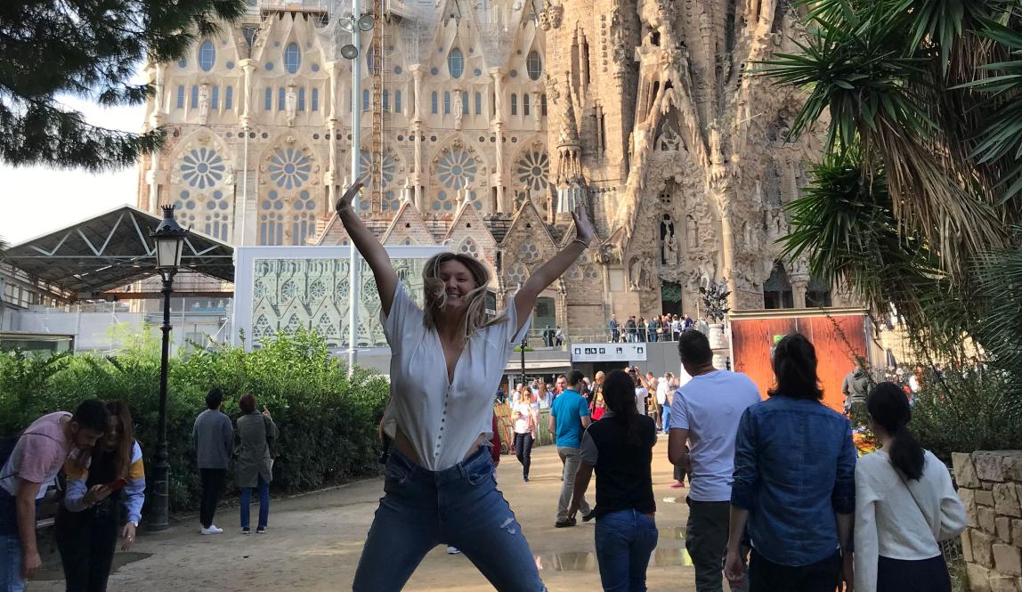 a student jumping for joy in from of Basílica de la Sagrada Família in Barcelona
