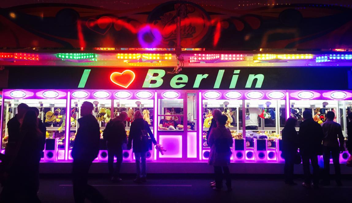 Passersby play in the claw machines beneath the "I love Berlin" sign