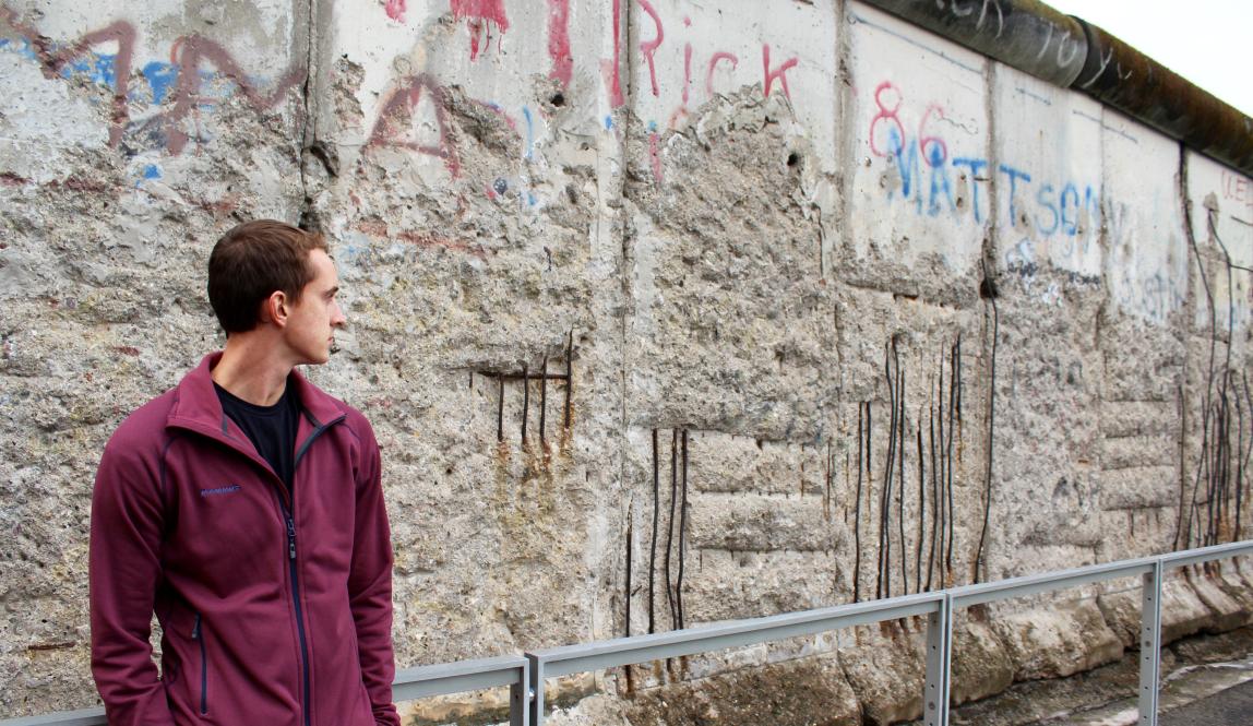 a student looks at the Berlin Wall