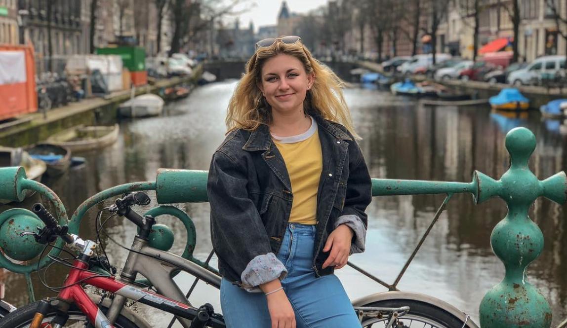 student posing in front of an Amsterdam canal