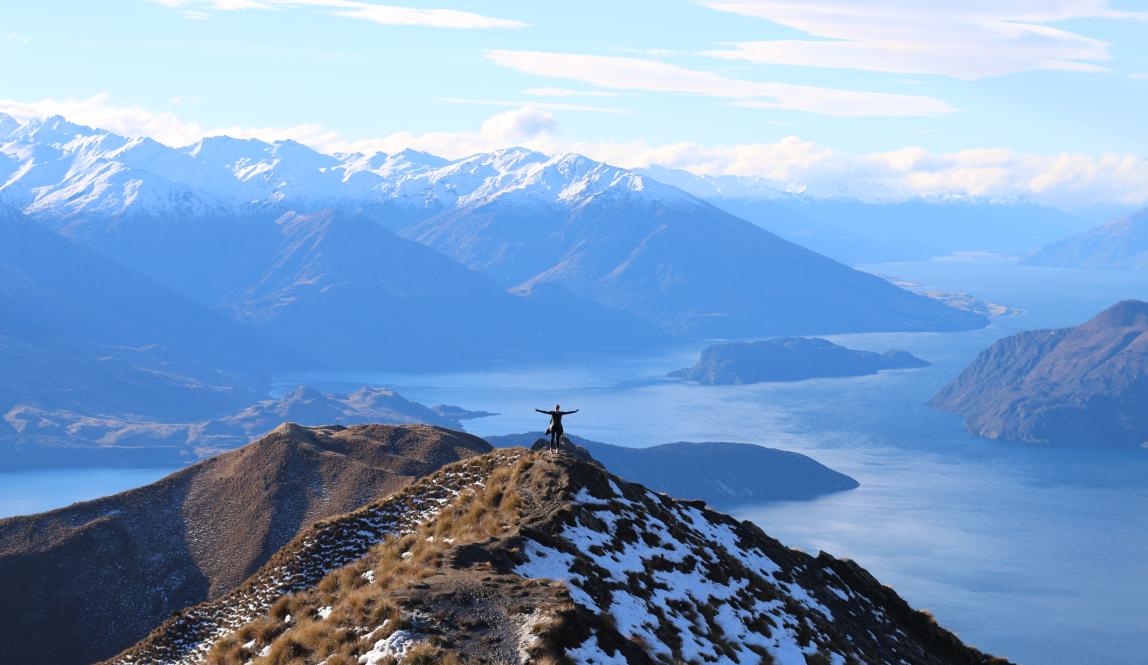 a student poses for a panoramic photo at Roy's Peak in New Zealand's South Island