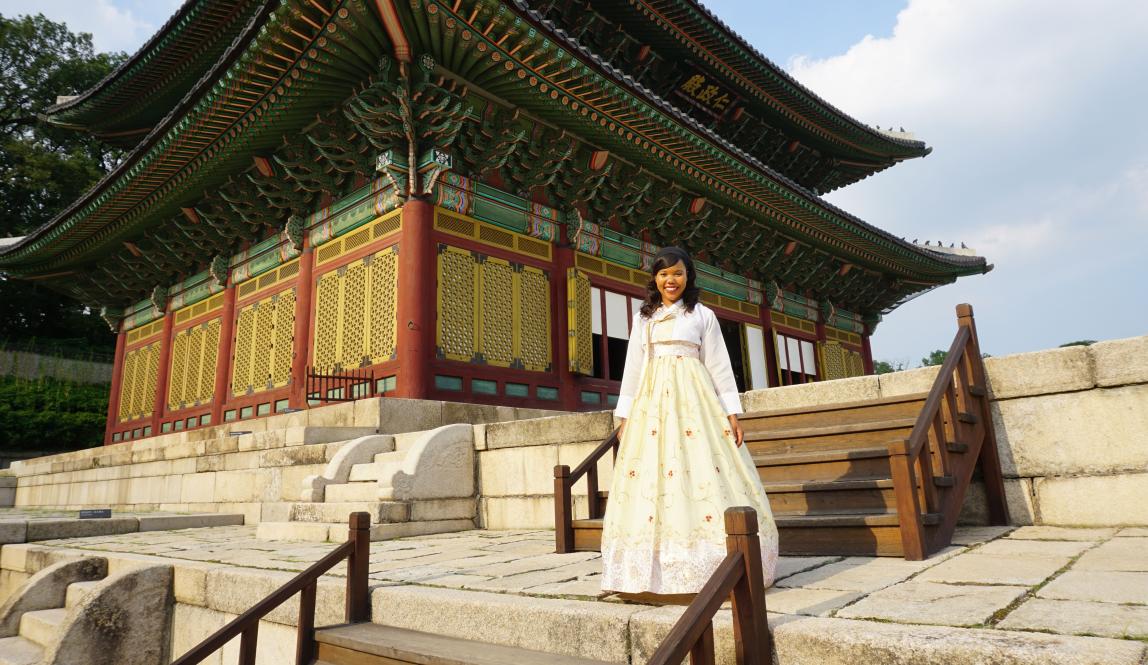a student poses for a photo in traditional Korean hanbok in front of Changgyeonggung Palace