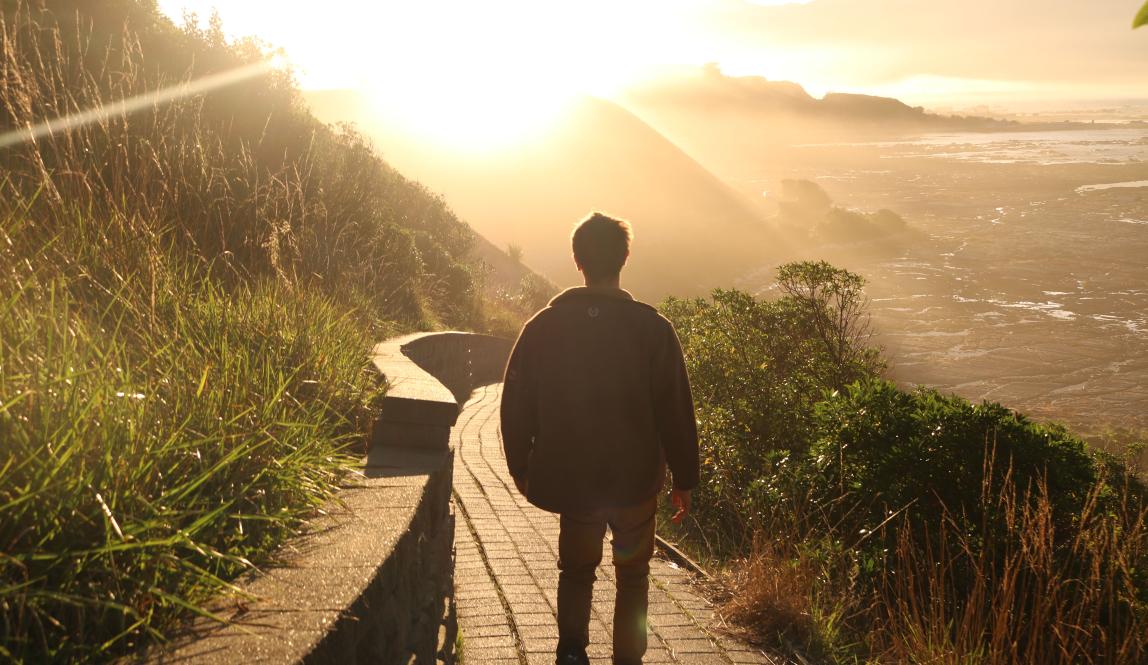 a student taking a coastal sunride hike in Kaikoura, New Zealand