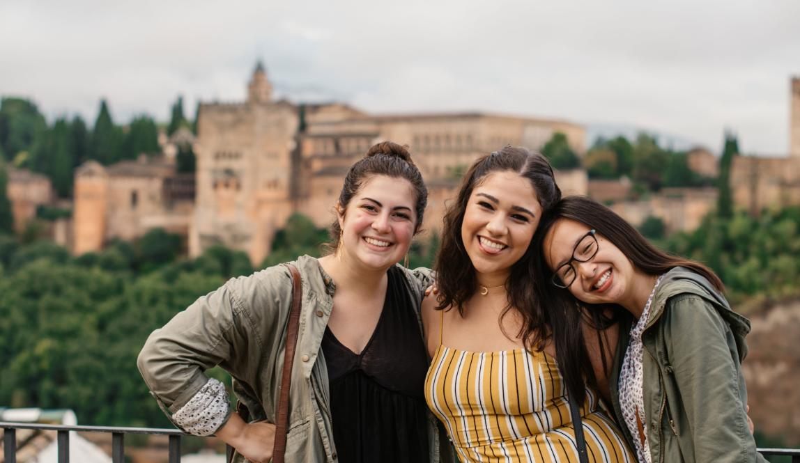 students pose for a photo in front of Alhambra Palace in Granda