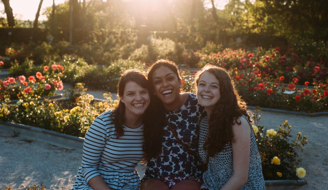 students smile for a photo in a flower-filled Madrid park