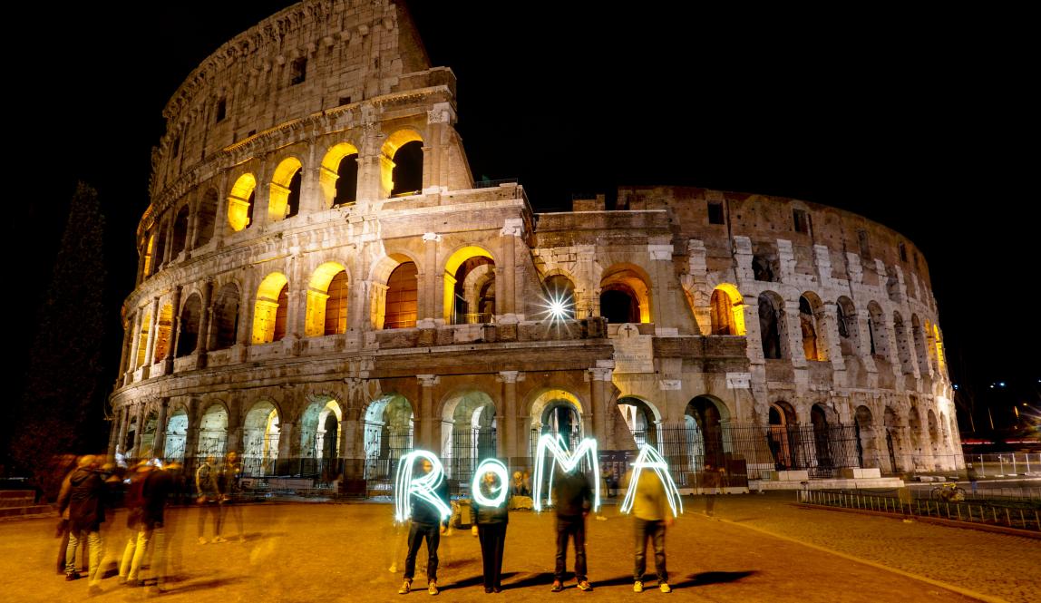 students use sparklers to spell out "ROMA" in front of the Colosseum in Rome