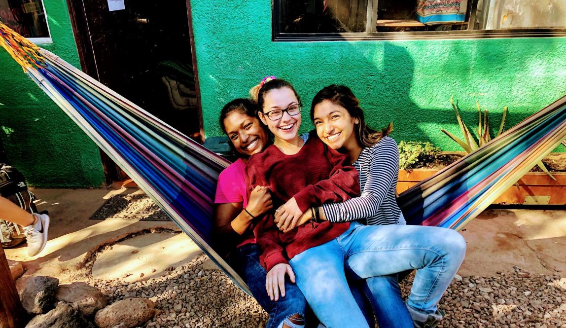 three students pose for a photo in a hammock in San Pedro de Atacama, Chile