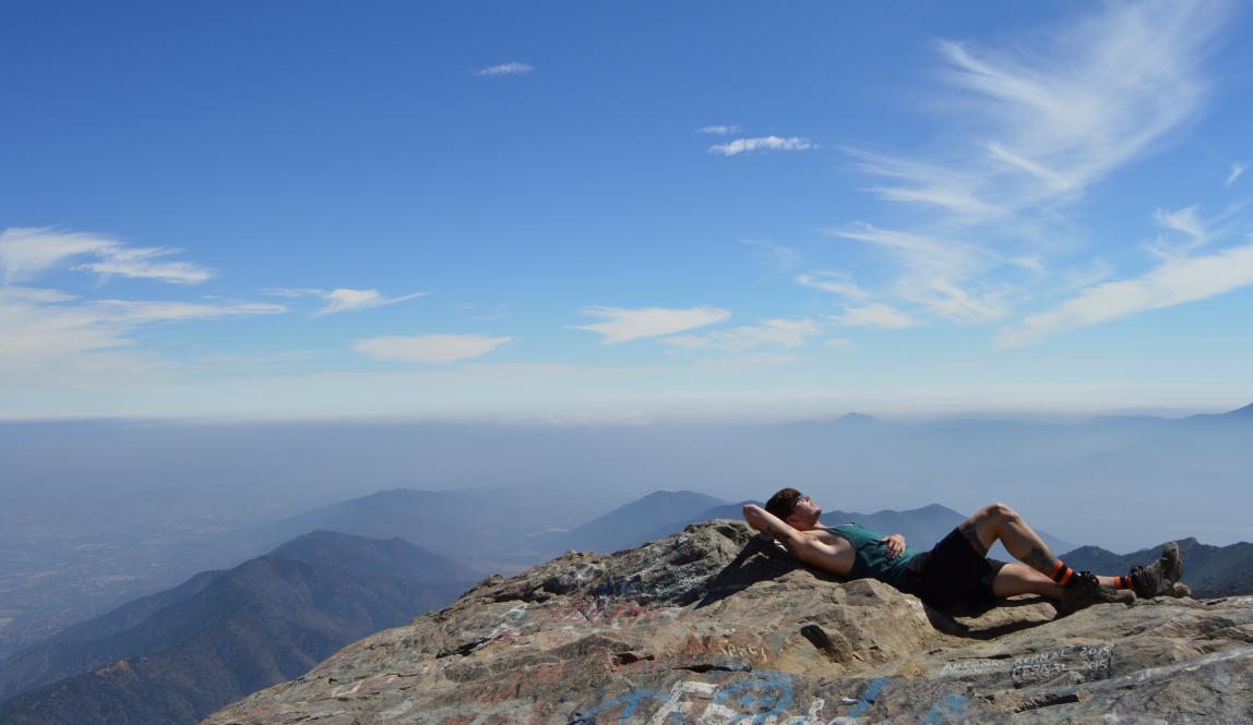 a student takes a rest atop a mountain in the Andes in Chile