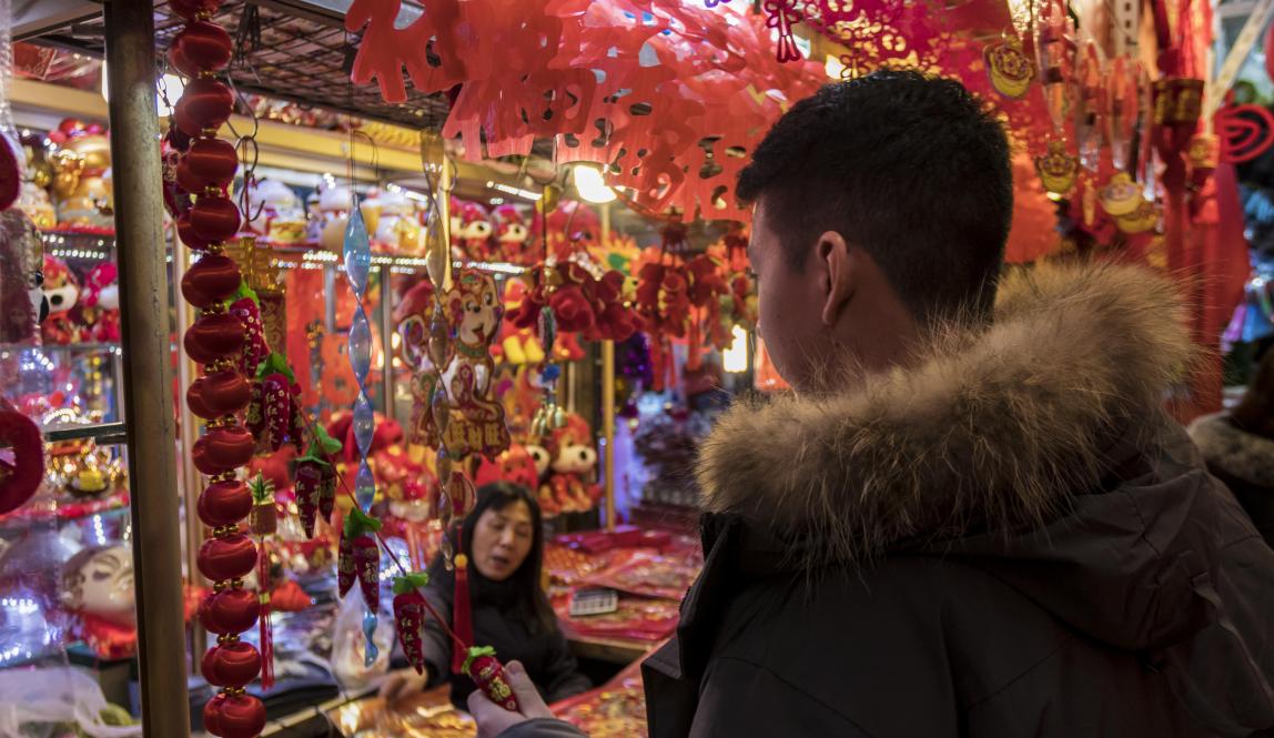 a student looks at souvenirs at a Chinese street market