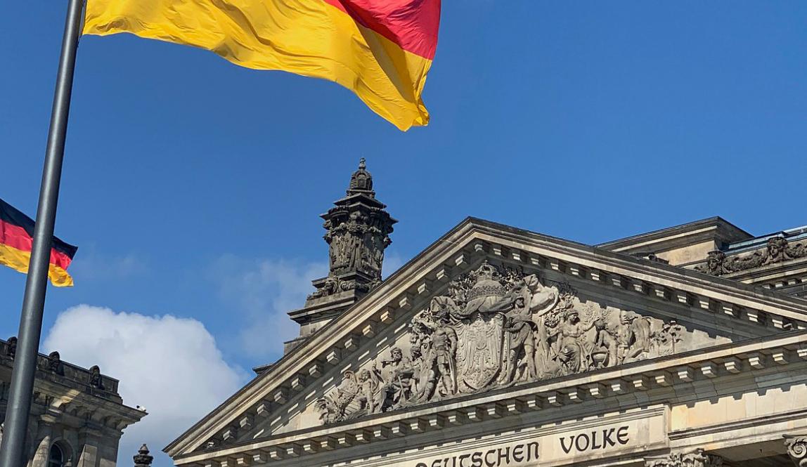 the German flag waving in front of Bundestag in Berlin