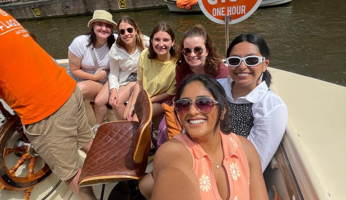 six girls pose for a photo on a canal tour of Amsterdam