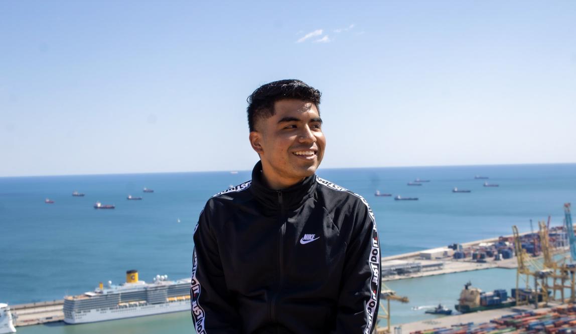 a student smiling in the sun at the pier in Barcelona