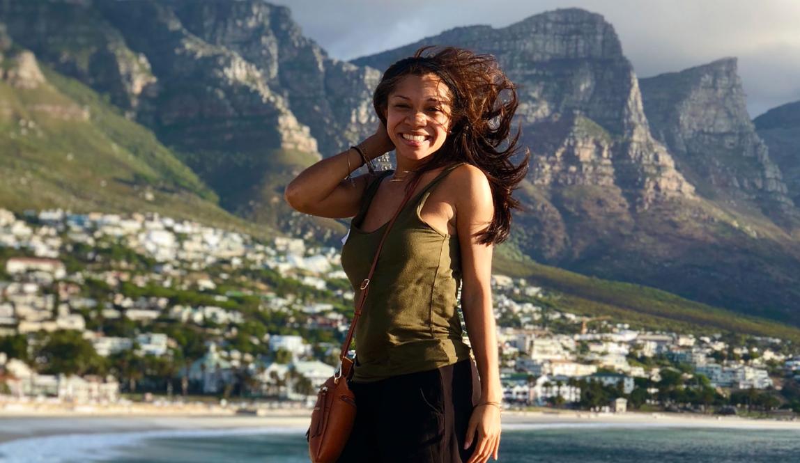 a student poses for a photo on the windy coast of Cape Town