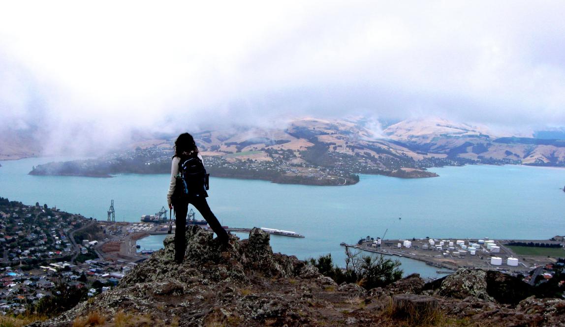 a student stares out over a city from the hilltop in New Zealand
