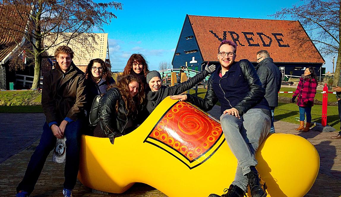 students pose for a photo in a giant clog in Amsterdam
