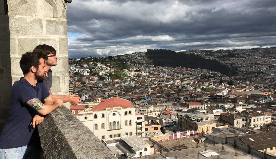 students looking out over Quito city from the top of a cathedral