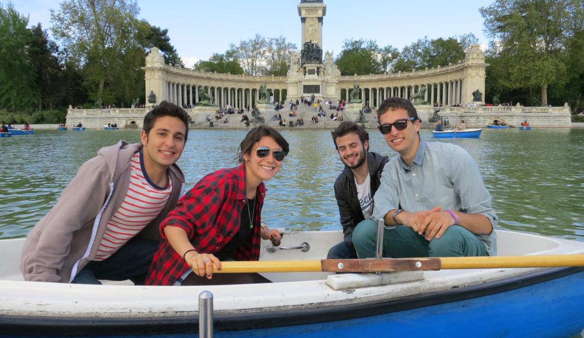 students pose for a photo while in a boat at Retiro Park Lake in Madrid