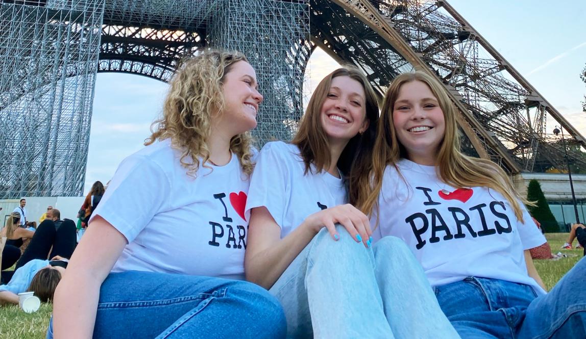 three female students having fun at the Eiffel Tower