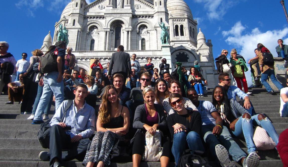 a group of students pose for a photo in front of le Sacre Coeur
