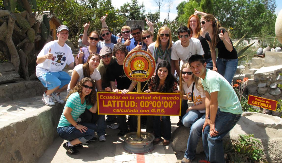 a group of students pose for a photo at the 0 latitude line at Mitad del Mundo (middle of the world)
