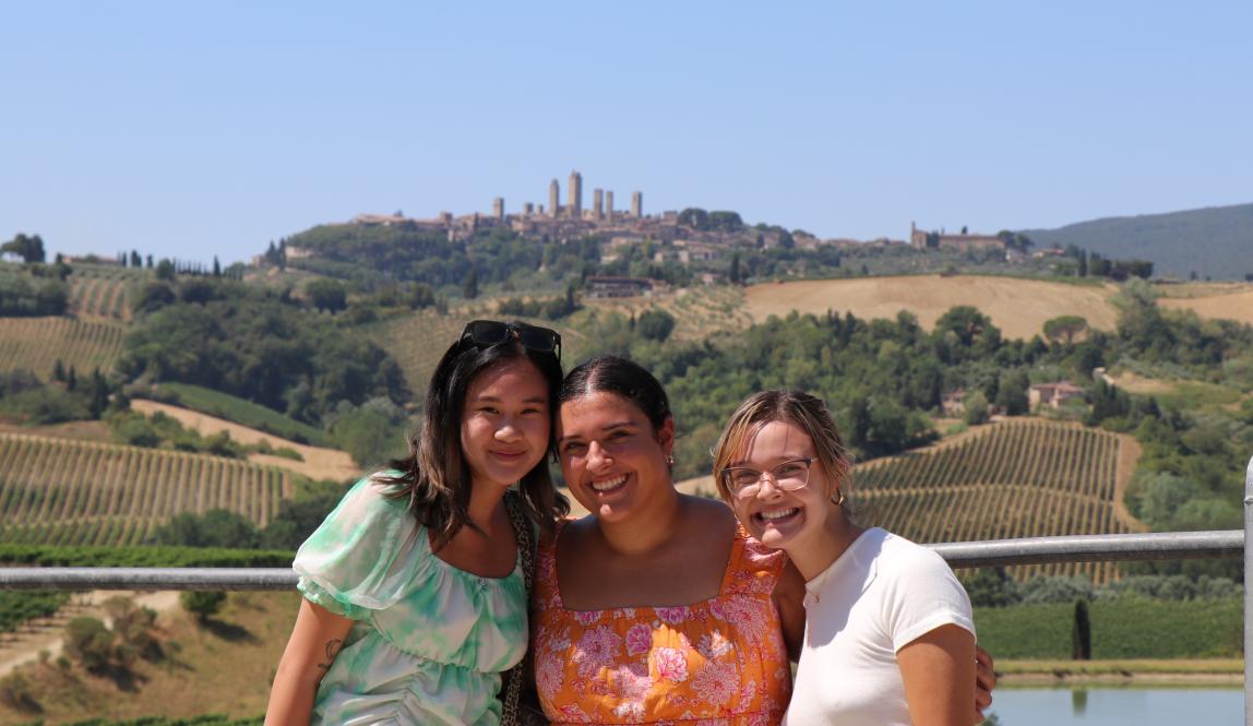 three students pose for a photo in front of Siena