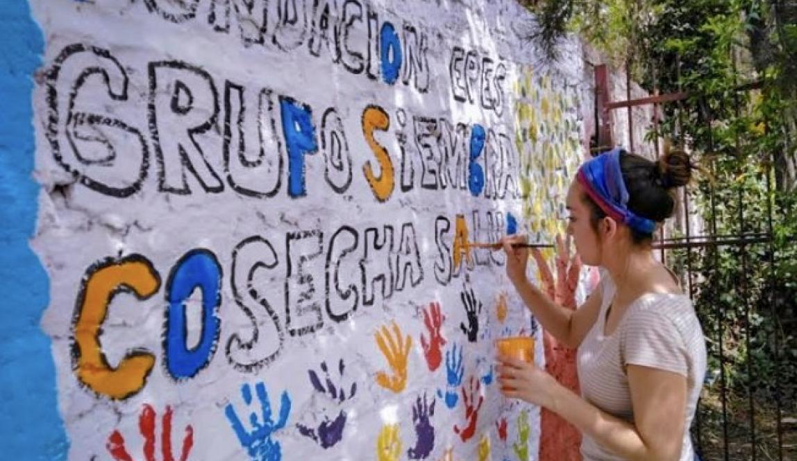 Student painting a mural in Santiago