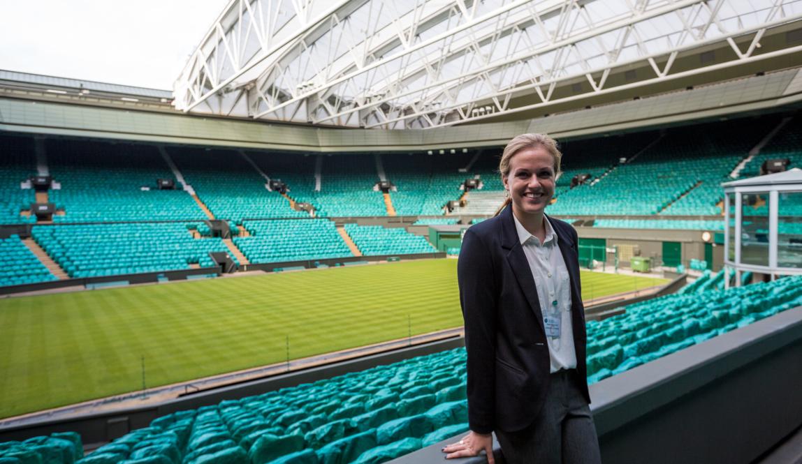 Student standing in the empty Wimbledon stadium