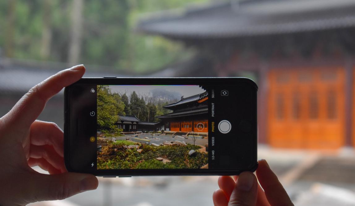 a student taking a photo of a temple in China on an iPhone