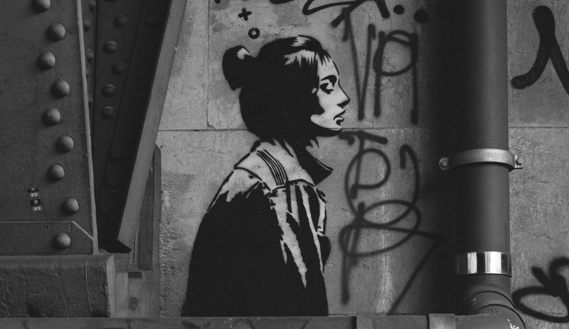 A wall with graffiti and the painting of a woman in Berlin, Germany.