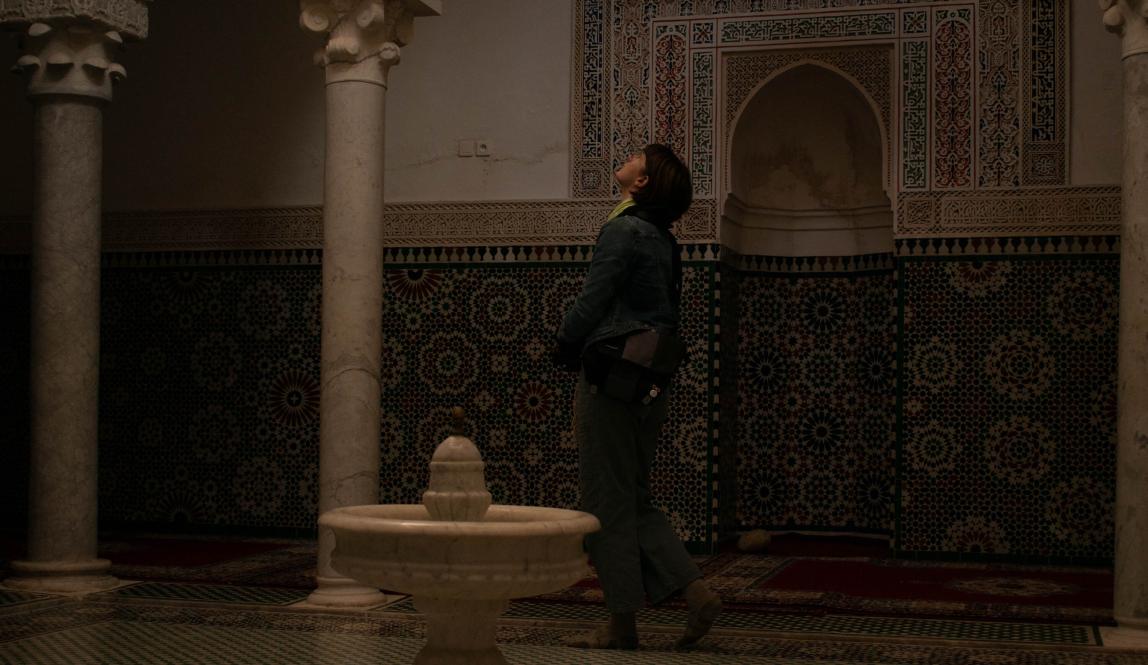 A student looks at the ceiling of the Mausoleum of Moulay Ismail.