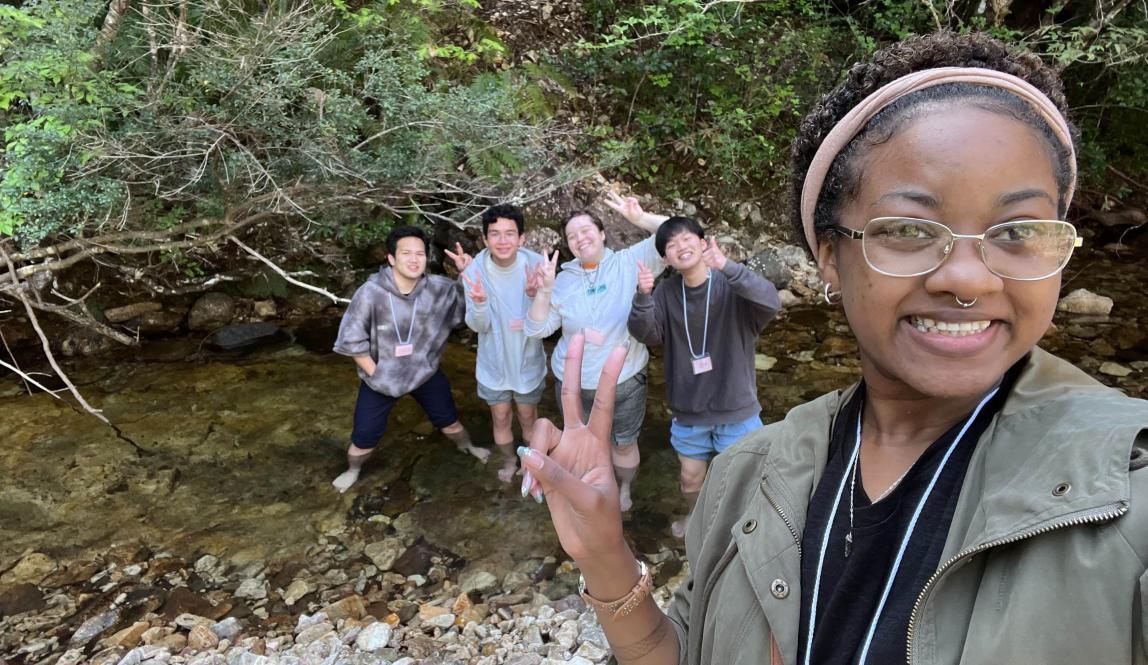 Author, Macks, posing with friends in a stream in they saw while hiking.