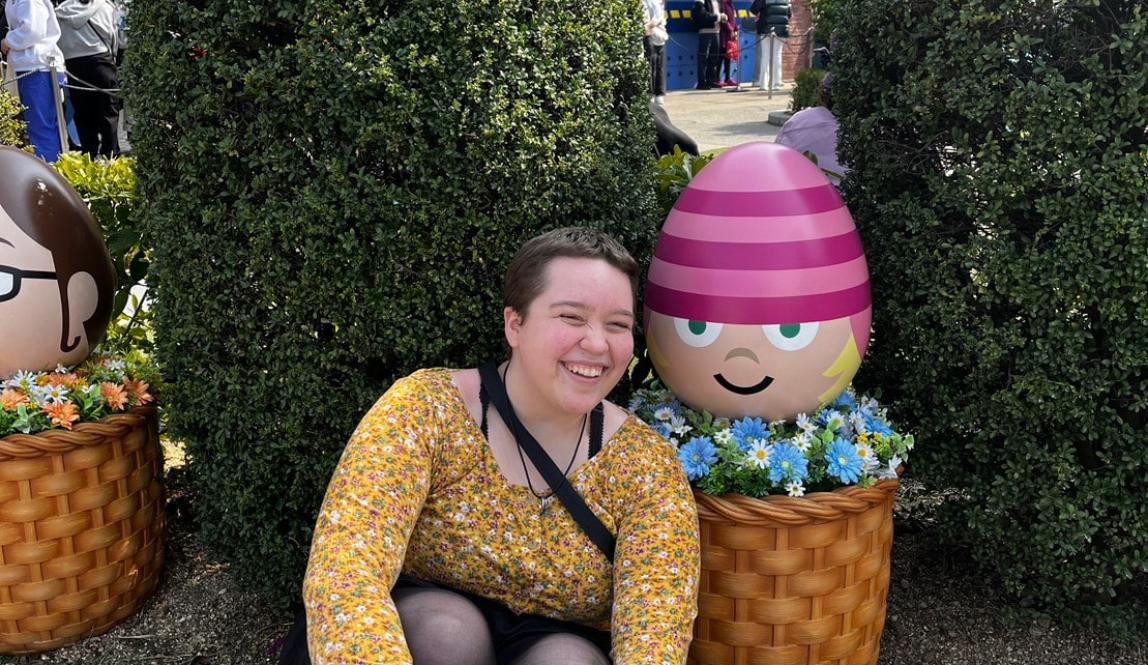 Author, Macks, sitting next to a small statue of Edith from Despicable Me.