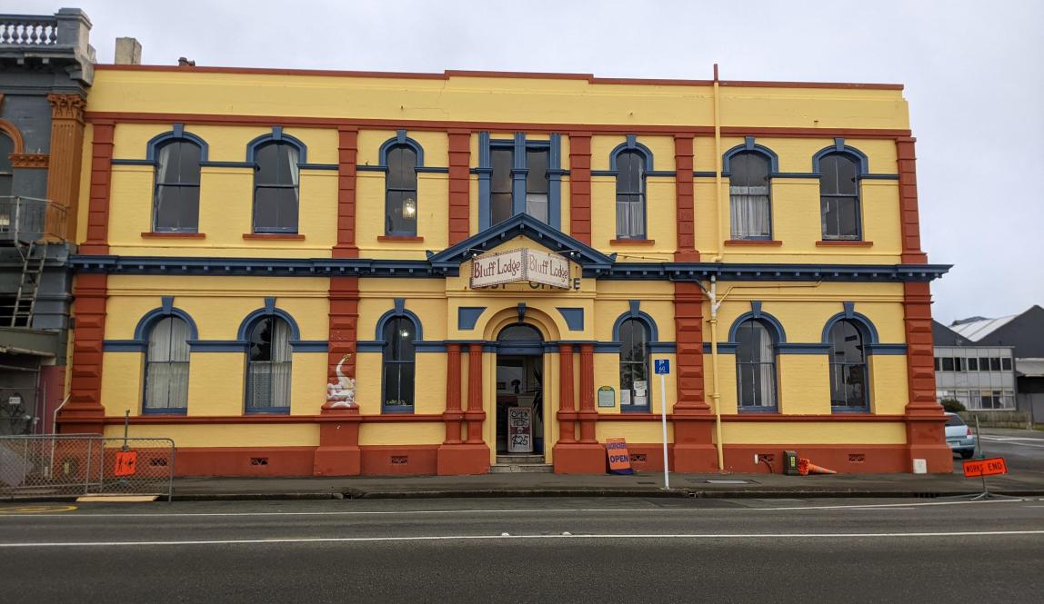 Front of a large two story building crisply painted orange/red, yellow, and blue 