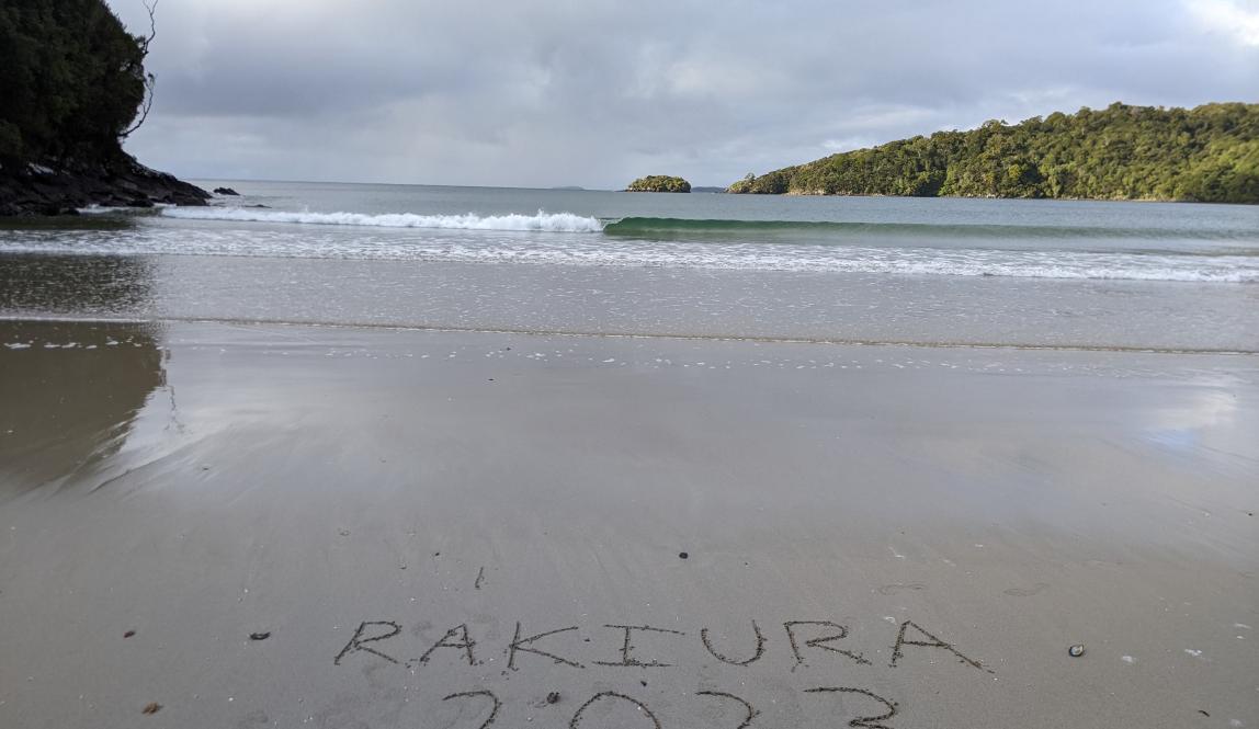 A beach with "Rakiura 2023" written in the sand