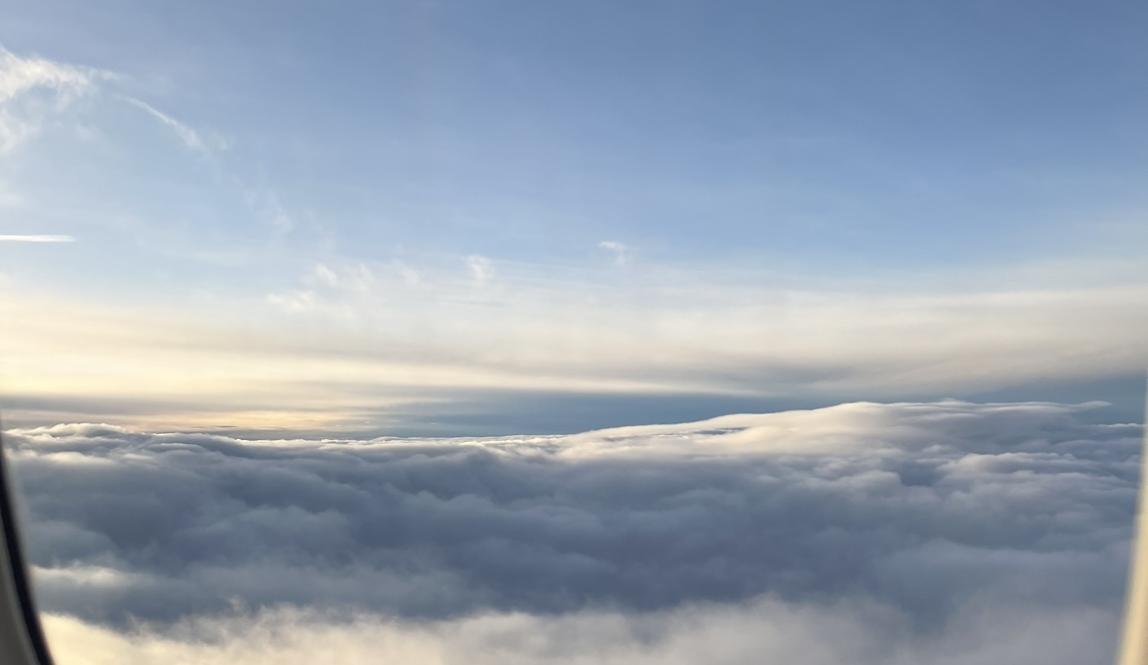view above the clouds from plane window 
