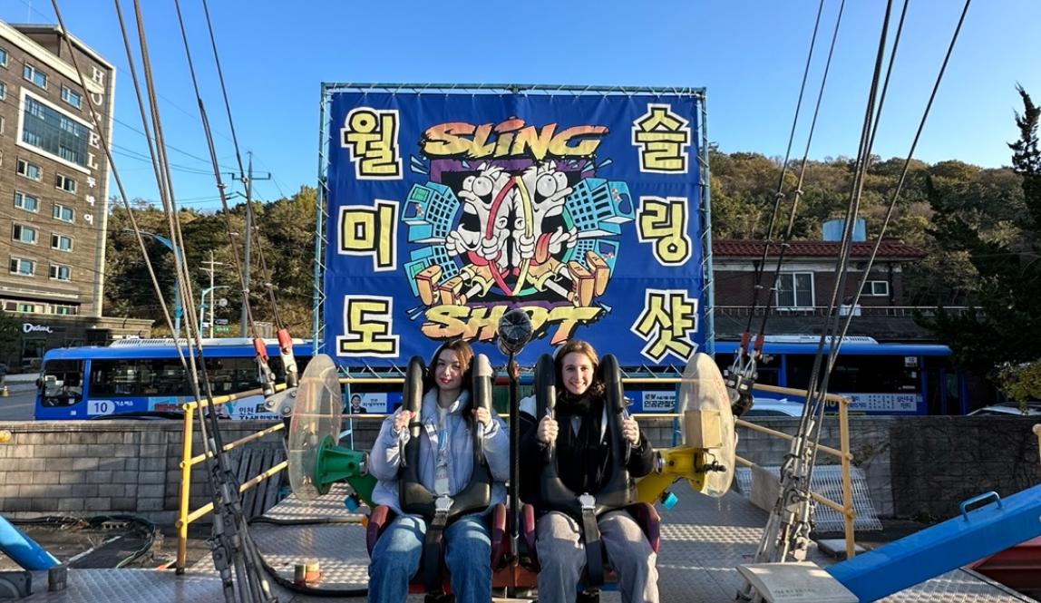Image of two people sitting in sling shot 