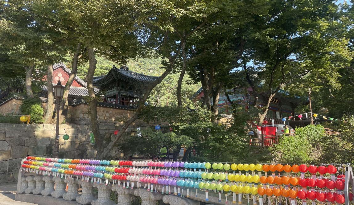 Bridge with multi-colored lanterns and traditional Korean building 