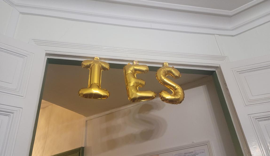 A doorway with taped letter balloons spelling IES