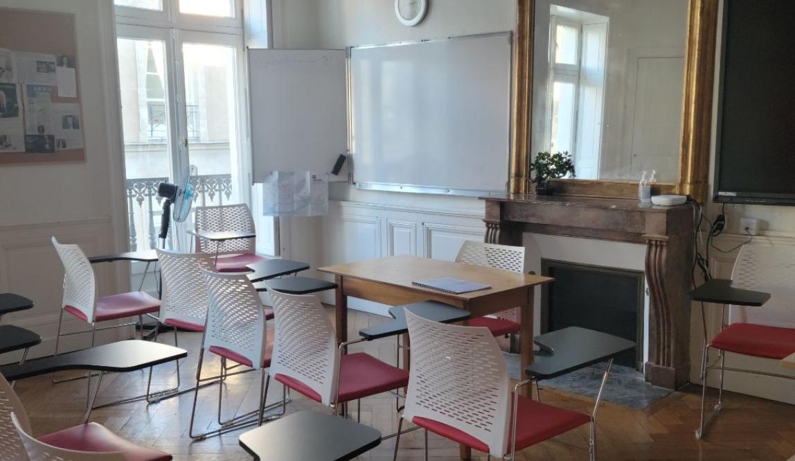 A classroom with a mirror behind the head desk facing rows of seats.