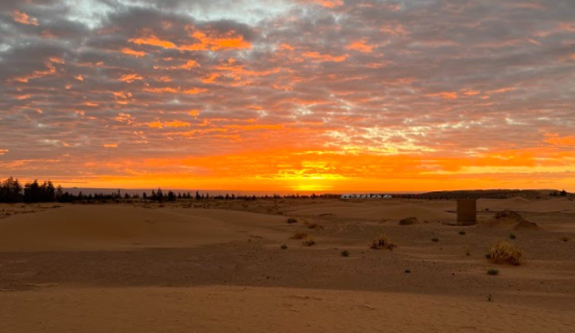 The sun setting the morning sky ablaze across the desert