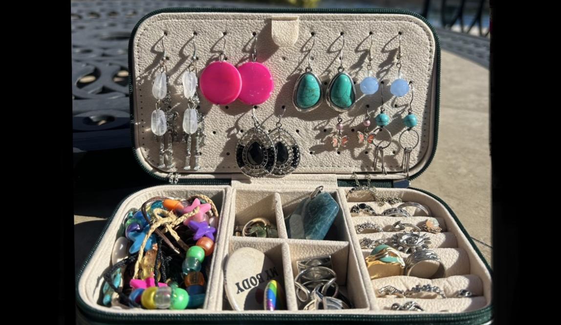 A travel jewelry case that contains earrings, bracelets, necklaces, and rings. 
