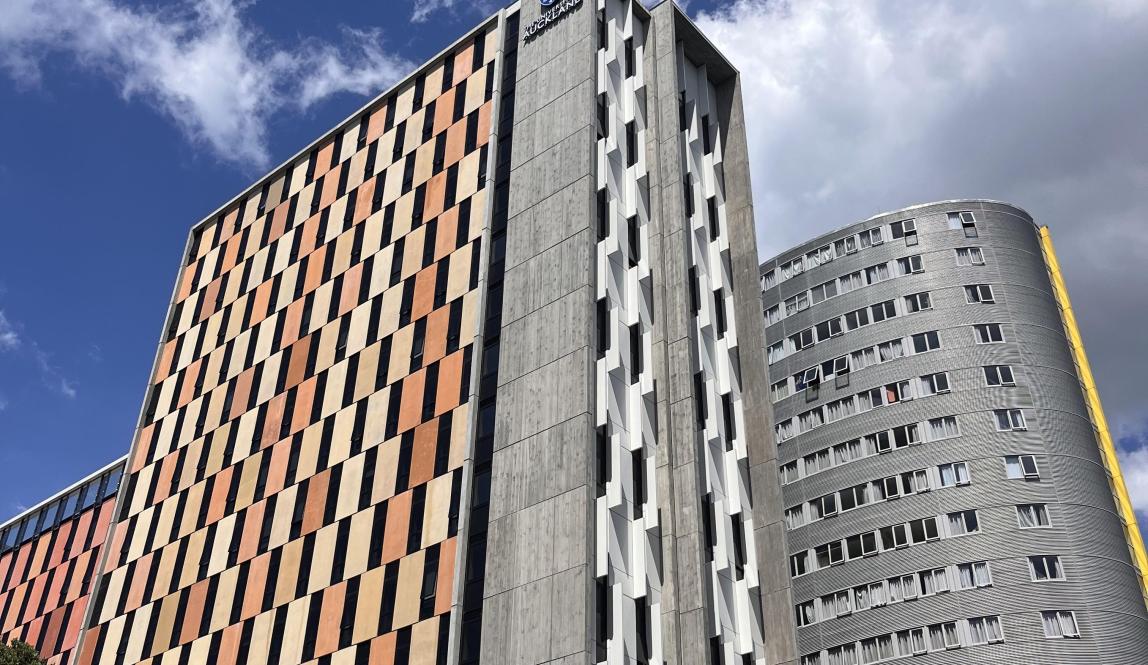 This photo shows an orange high rise building that houses students at University of Auckland.