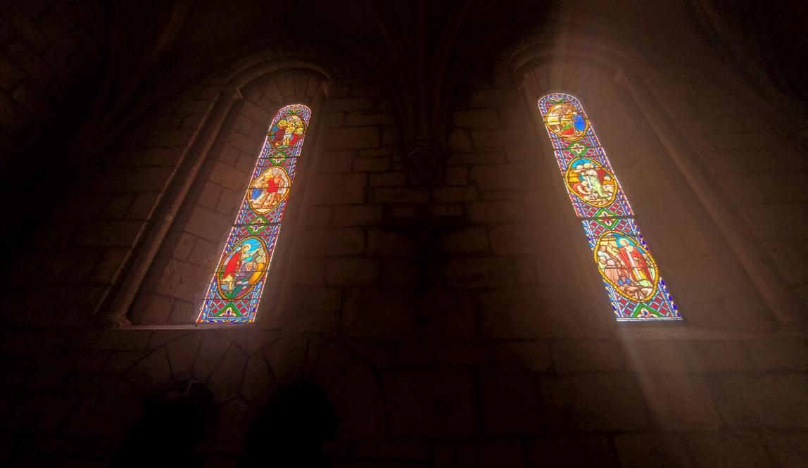 A warm light streaming in from stained glass windows that feels both humbling and uplifting.