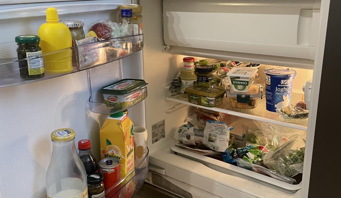 An open fridge that is full with food.
