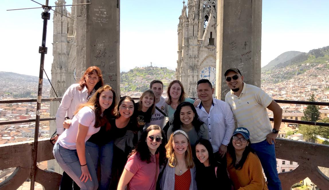 a group of IES Abroad students and staff standing atop Iglesia La Basilica, overlooking Quito city