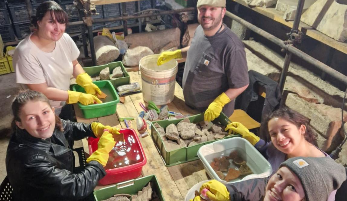 Students smiling with artifacts in the Colosseum during their internship
