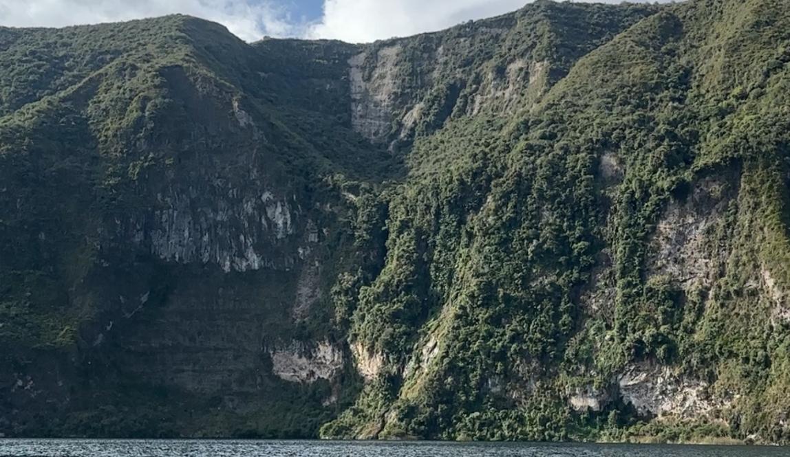A mountainous landscape with a lake in front. Taken from the sightline of the water.